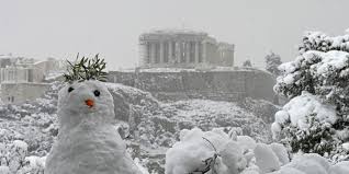 Un bonhomme de neige devant une vue du Parthénon sur l'Acropole recouverte de neige à Athènes le 16 février 2021 AFP / ARIS MESSINIS